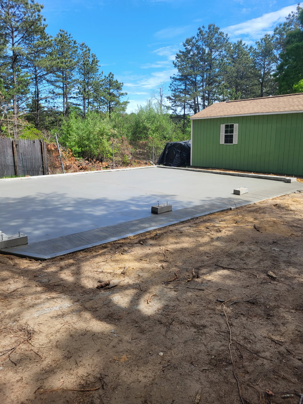 Freshly poured concrete slab in a Long Island backyard by Forte Brick and Concrete